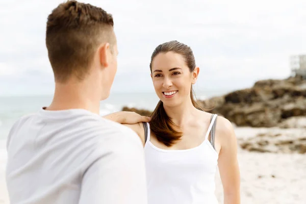 Corredores. Pareja joven haciendo ejercicio y esteretizando en la playa —  Fotos de Stock