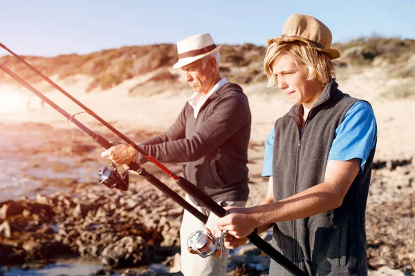 Hombre mayor pescando con su nieto — Foto de Stock