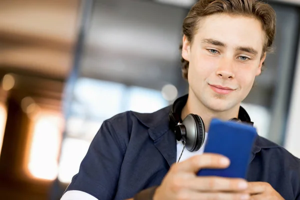 Pewny siebie, młody człowiek w inteligentne odzież codzienna, trzymając telefon — Zdjęcie stockowe