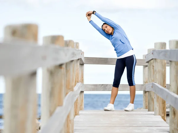 Junge Frau am Strand macht Übungen — Stockfoto