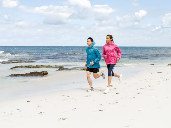 Junges Paar rennt am Meer entlang — Stockfoto