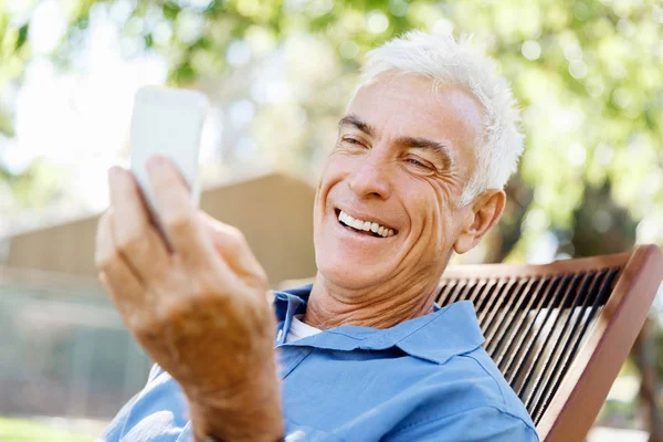 Lomature man buitenshuis gebruik mobiele telefoon — Stockfoto