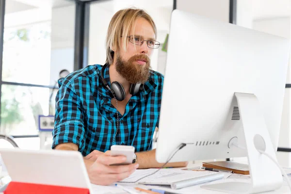 Genç adam ofiste çalışıyor.