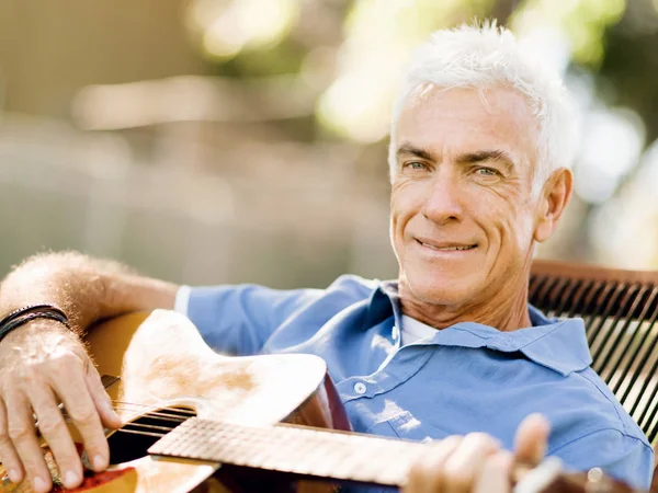 Hombre mayor tocando la guitarra al aire libre — Foto de Stock