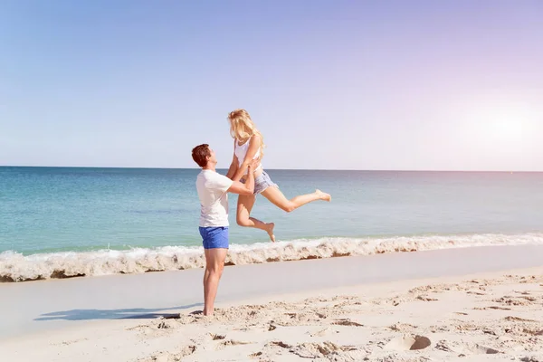 Joyeux couple sautant en vacances à la plage — Photo