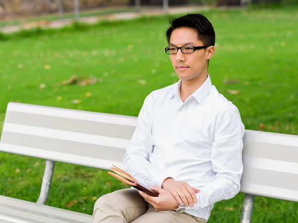 Not Defteri ile bankta oturmuş çekici düşünceli işadamı