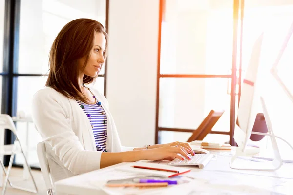 Porträt einer Geschäftsfrau, die im Büro am Computer arbeitet — Stockfoto