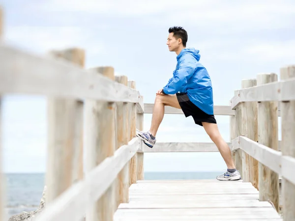 Jonge man doen oefening op het strand — Stockfoto