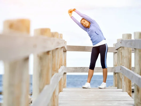 Young woman at the beach doing exercises — Stock Photo, Image