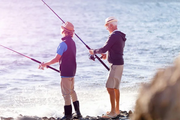 Yaşlı adam torunuyla balık tutuyor. — Stok fotoğraf