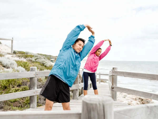 Egzersizleri yapıyor deniz kenarında genç Çift