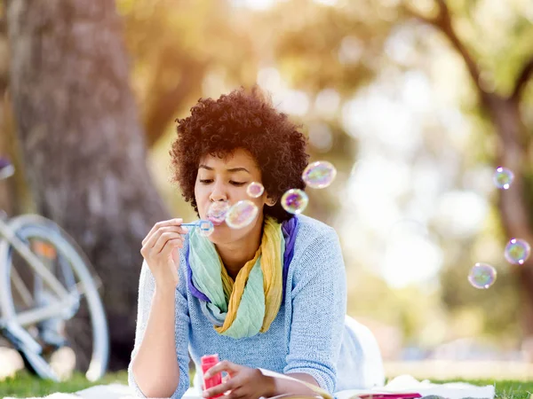 Güzel kadın parkta kabarcıklar üfleme