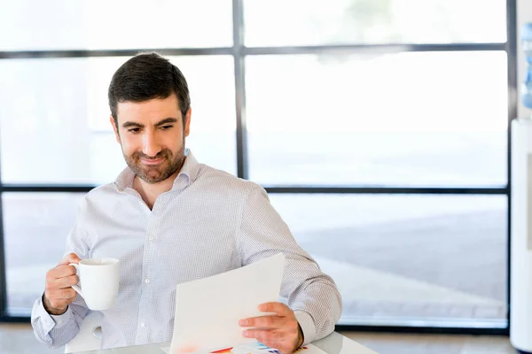 Stilig ung man håller papper i office — Stockfoto