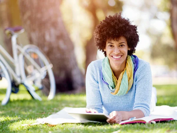 Jeune femme utilisant une tablette dans le parc. — Photo