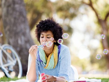 Güzel kadın parkta kabarcıklar üfleme