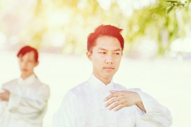 Yakışıklı adam Thai Chi yapıyor.