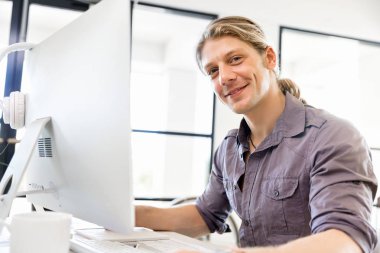 Bilgisayarda çalışan yakışıklı işadamı