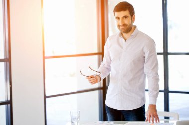 Ofiste duran genç beyaz iş adamı