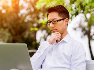 İş adamı parkta bir gazete okuyor