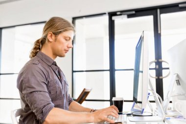 Bilgisayarda çalışan yakışıklı işadamı