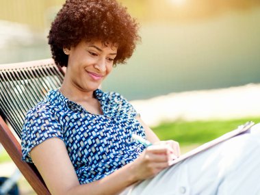 Güzel genç kadın açık havada günlüğüne yazma