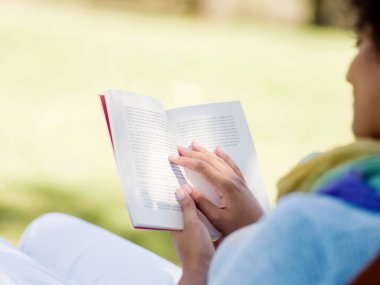 genç kadın parkta bir kitap okuma