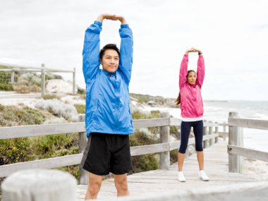 Egzersizleri yapıyor deniz kenarında genç Çift