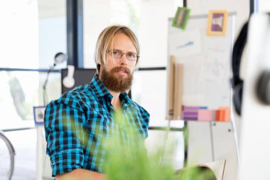 Genç adam ofiste çalışıyor.