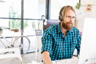 Genç adam ofiste çalışıyor.