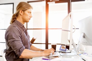 Bilgisayarda çalışan yakışıklı işadamı