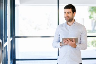 Genç yakışıklı işadamı onun touchpad ayakta kullanma office