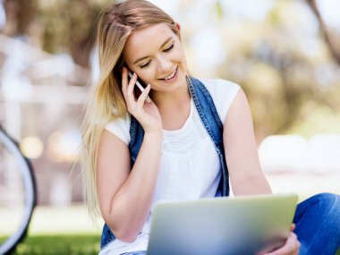 Dizüstü bilgisayar ile bir çayırda açık havada çalışan kadın