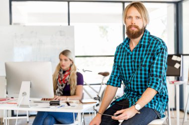 Genç adam ofiste çalışıyor.