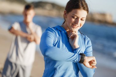 Kalp atış hızı monitörünü plajda çalışan kadınla Runner