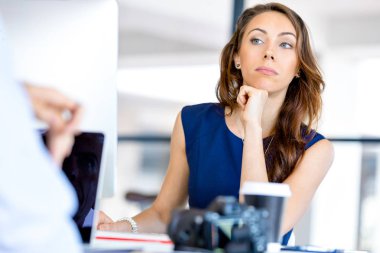 masada oturan ve çalışan genç iş kadını
