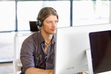 Kulaklıklar ile ofiste genç adam