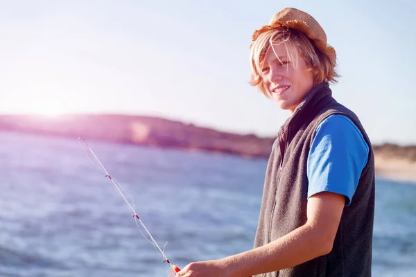 Adolescent garçon pêche en mer — Photo