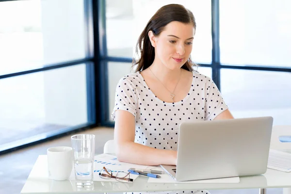 Porträt einer Geschäftsfrau, die im Büro am Computer arbeitet — Stockfoto