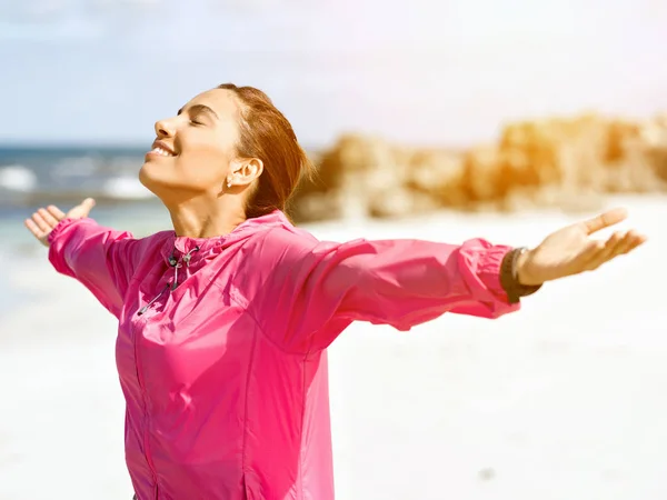 Young woman in sportswear standing at the seaside — Stock Photo, Image