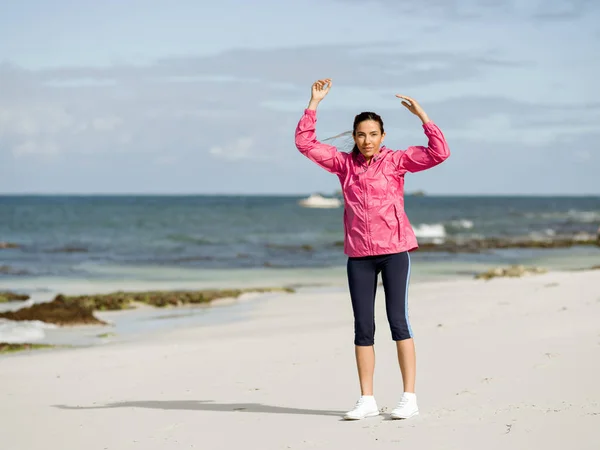 Genç kadın plajda egzersizleri yapıyor — Stok fotoğraf