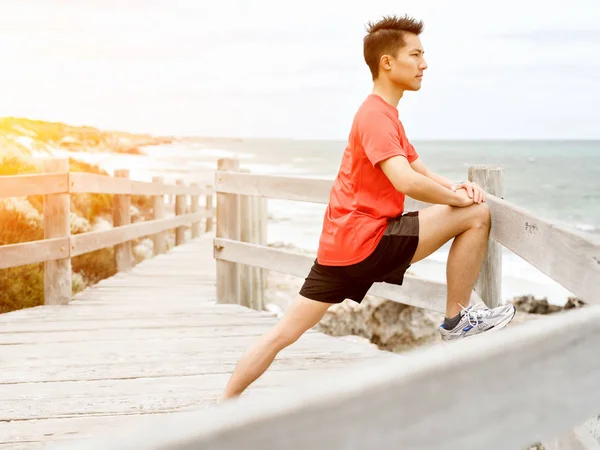 Mladý muž dělá cvičení na pláži — Stock fotografie