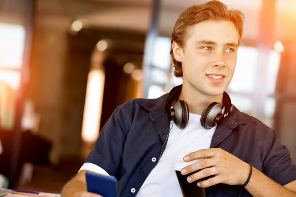 Confident young man in smart casual wear holding phone — Stock Photo, Image