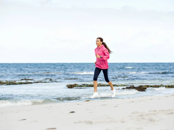 Młoda kobieta jogging na plaży — Zdjęcie stockowe