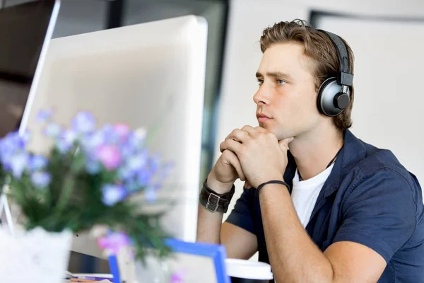 Young man in the office with headphones — Stock Photo, Image