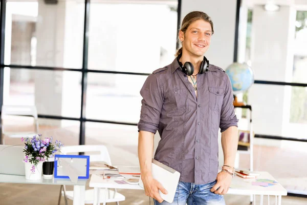 Young caucasian businessman standing in office — Stock Photo, Image