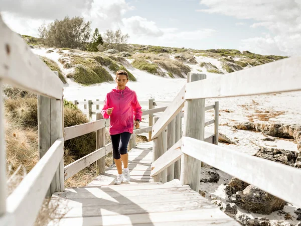 Mujer joven corriendo en la playa — Foto de Stock