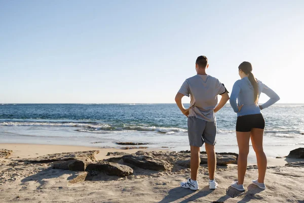 Ungt par på stranden utbildning tillsammans — Stockfoto