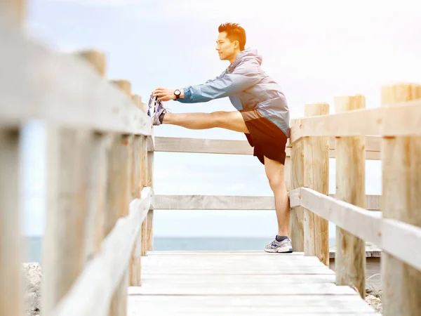 Mladý muž dělá cvičení na pláži — Stock fotografie