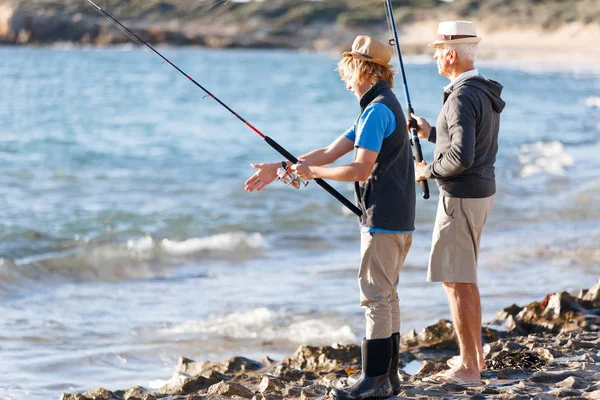 Hombre mayor pescando con su nieto —  Fotos de Stock