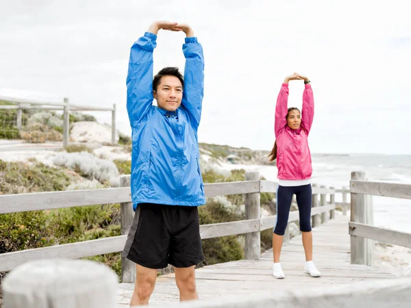Egzersizleri yapıyor deniz kenarında genç Çift